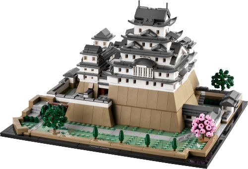 Visuel officiel du LEGO Himeji 21060 : donjon blanc à toits gris foncé superposés, grandes bases beiges, enceintes et allées, deux grands arbres verts et un grand arbre rose sur un socle noir.