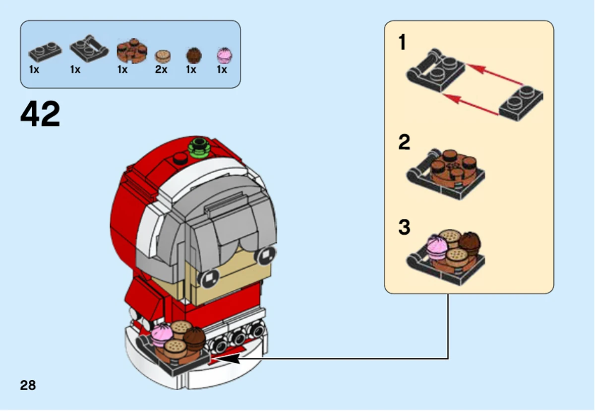 Notice officielle LEGO 40274, livret 1, page 28 : L’étape 42 assemble un petit plateau noir avec deux biscuits imprimés et deux gâteaux, puis le fixe devant la mère Noël.