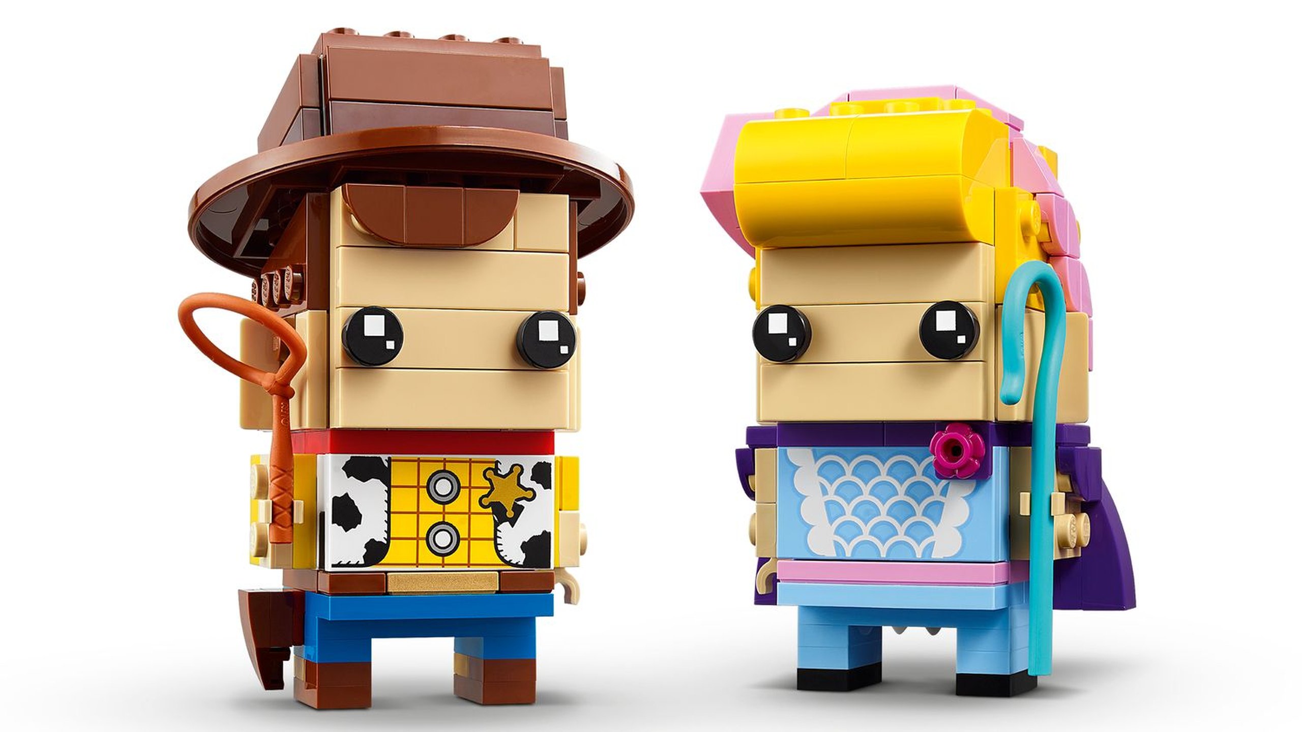LEGO 40553 Woody et La Bergère : Woody associe chapeau marron, chemise imprimée de shérif, pantalon bleu et lasso orange foncé. La Bergère porte une robe bleu clair à festons blancs, des cheveux jaunes et un bonnet rose ; sa houlette bleu azur et sa cape violette complètent le duo.