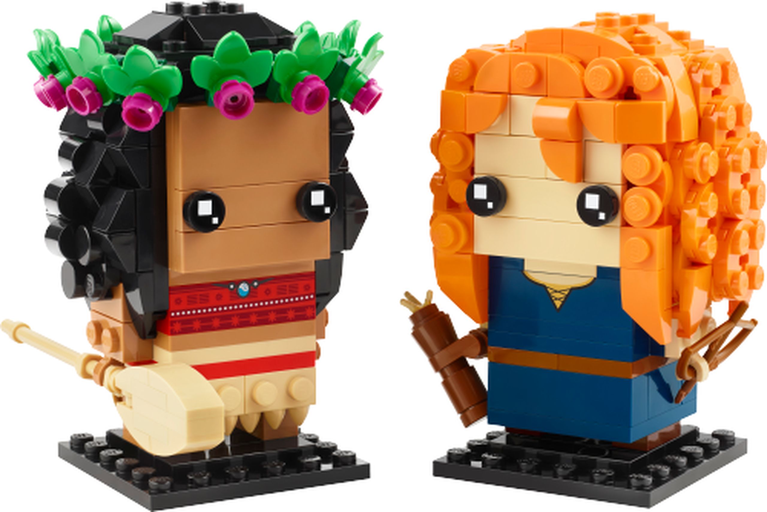 LEGO 40621 Vaiana et Mérida : Vaiana porte un haut rouge imprimé et une jupe beige ; ses cheveux noirs sont surmontés d’une couronne de feuilles vertes et de petites fleurs magenta. Sa pagaie est construite avec plusieurs pièces. Mérida a une chevelure orange bouclée, une robe bleu foncé au col imprimé doré, un arc marron et un carquois construit en briques. Les deux personnages reposent sur des socles noirs.